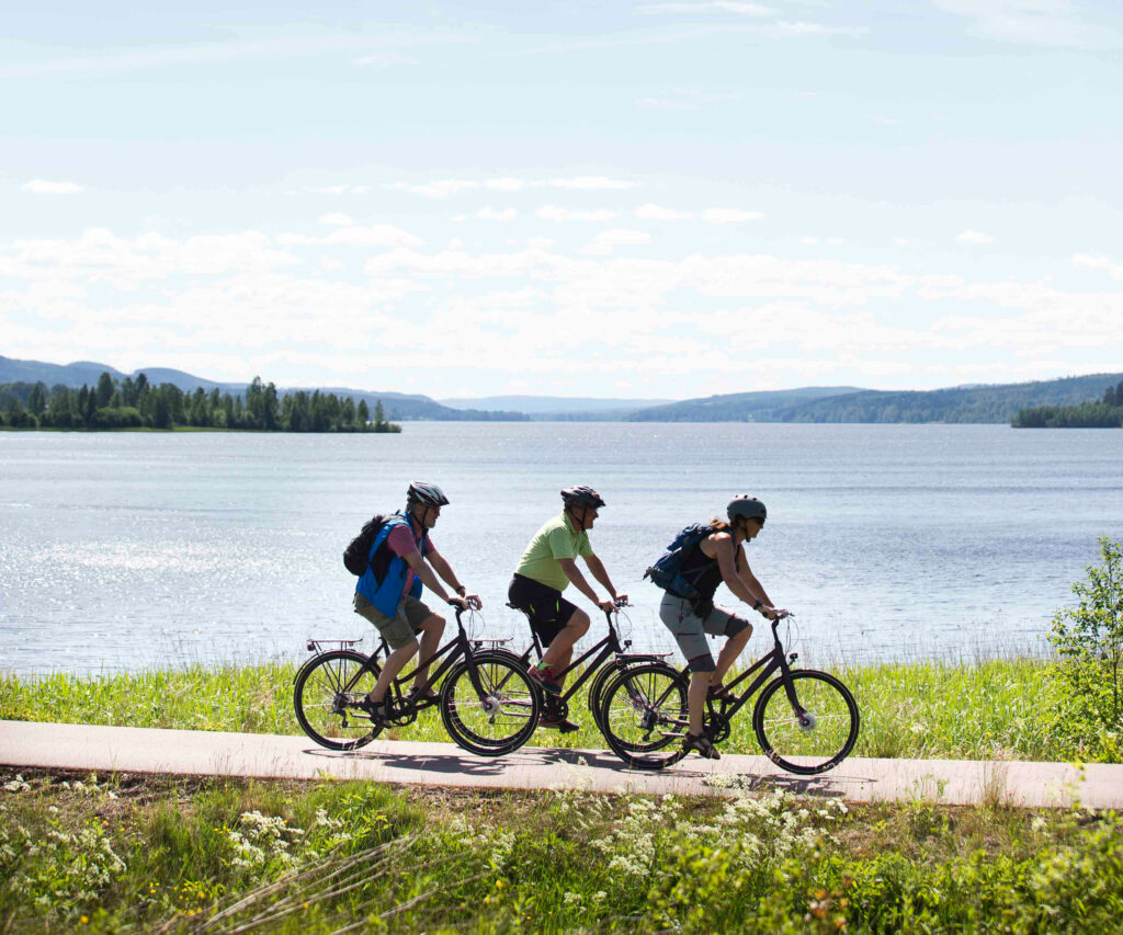 Tre personer som cyklar vid vattnet