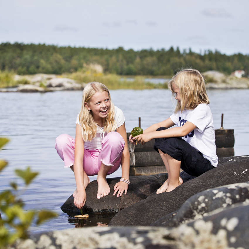 Barnen leker med barkbåt i Vänerviken