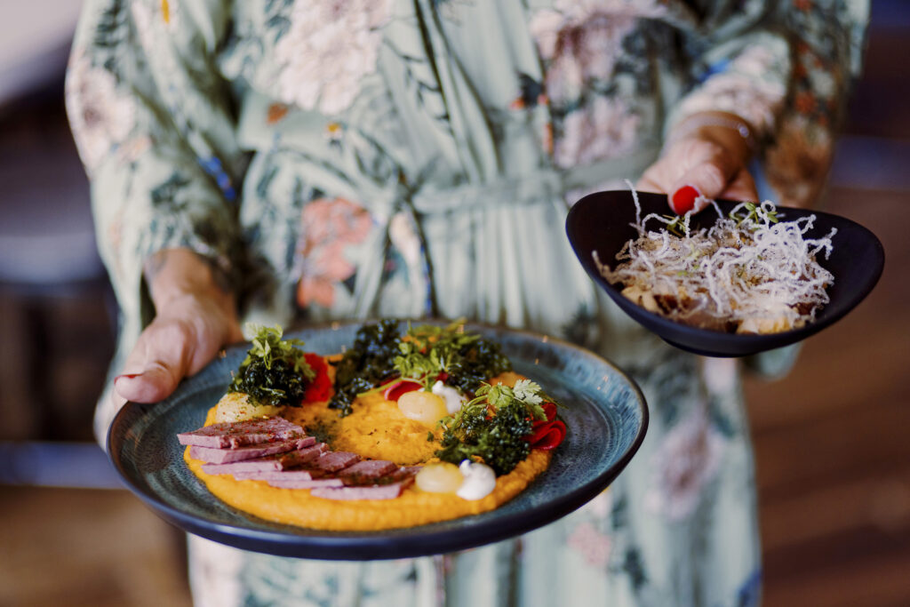 Kvinna som håller i två tallrikar