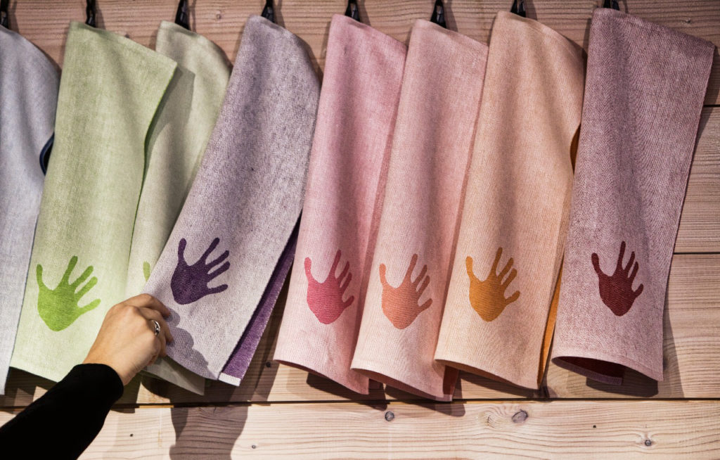 Beautiful towels in different colors hanging on a wall